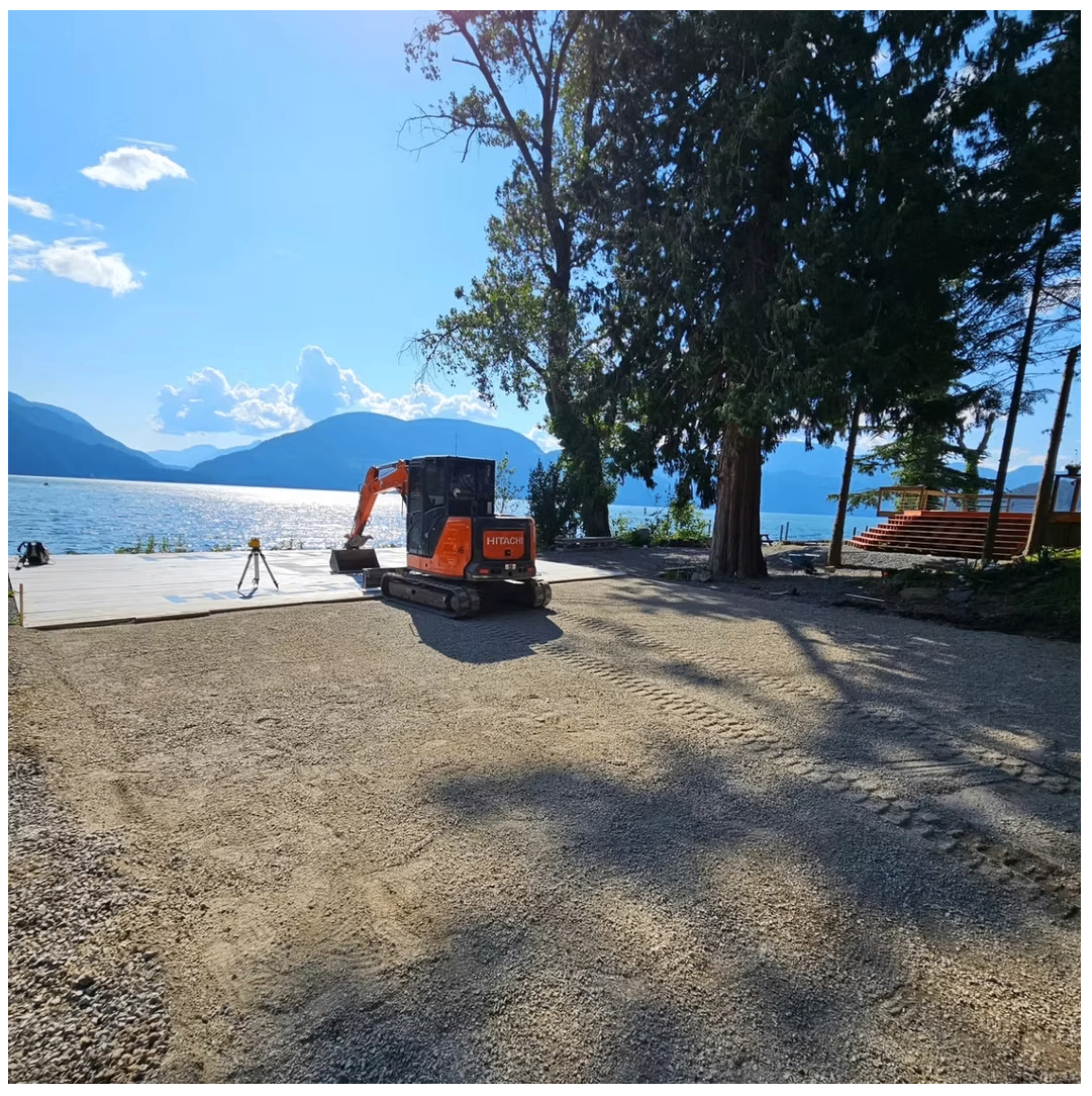 Radius Excavation Hitachi mini excavator preparing a gravel pad at a lakeside property with mountains in the background