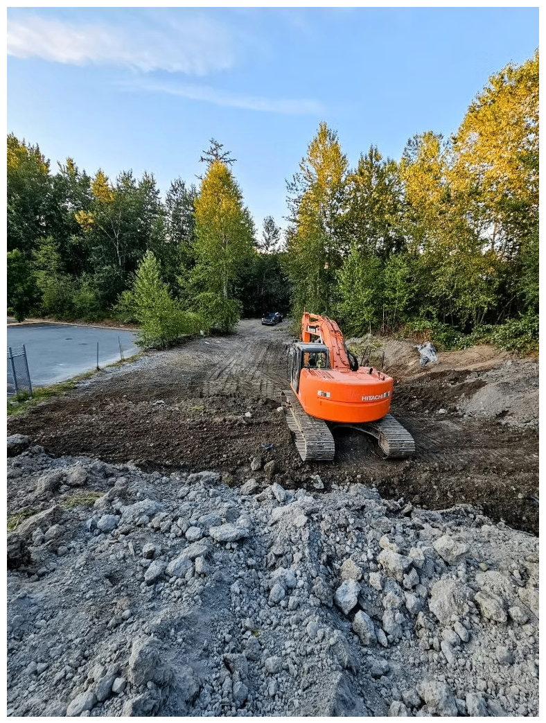 Hitachi excavator rough grading a wooded lot for a new residential build in the Lower Mainland
