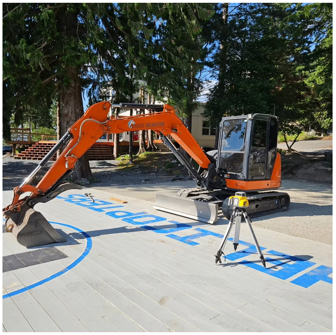 Radius Excavation mini excavator and rotary laser level setting grade on a residential deck platform in BC