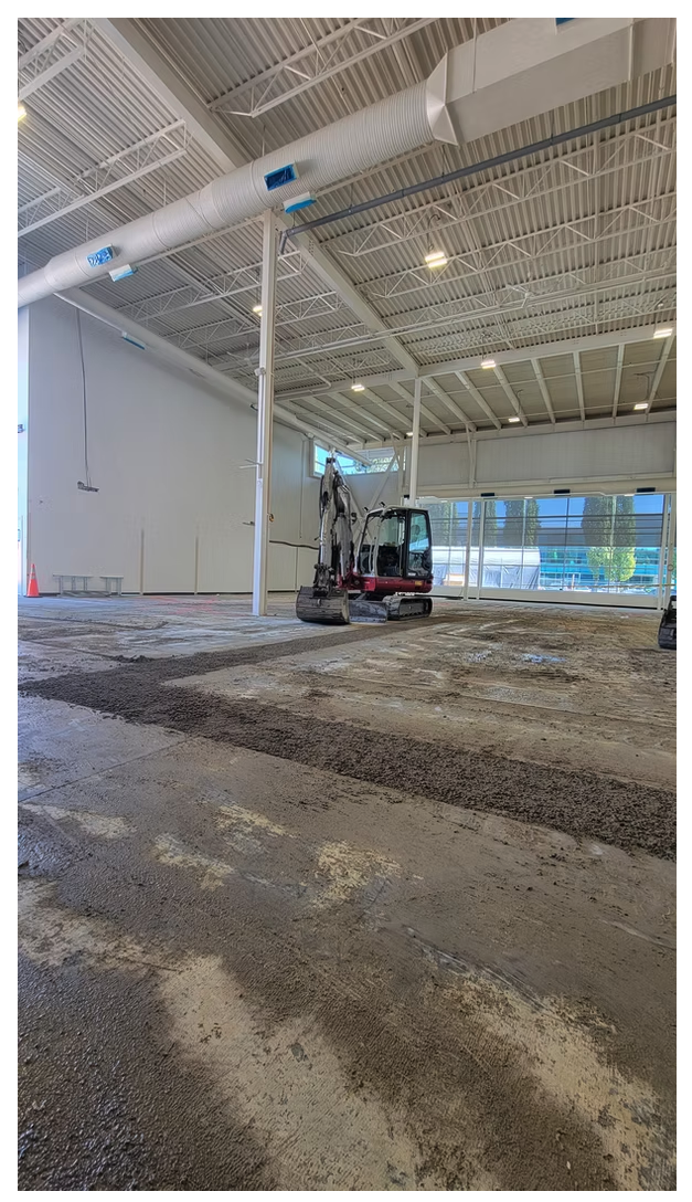 Mini excavator removing concrete slab inside a commercial building for interior renovation excavation